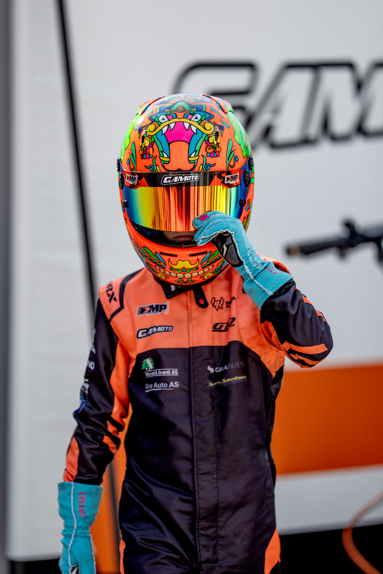 Full-body image of Guido in racing suit and helmet in the paddock