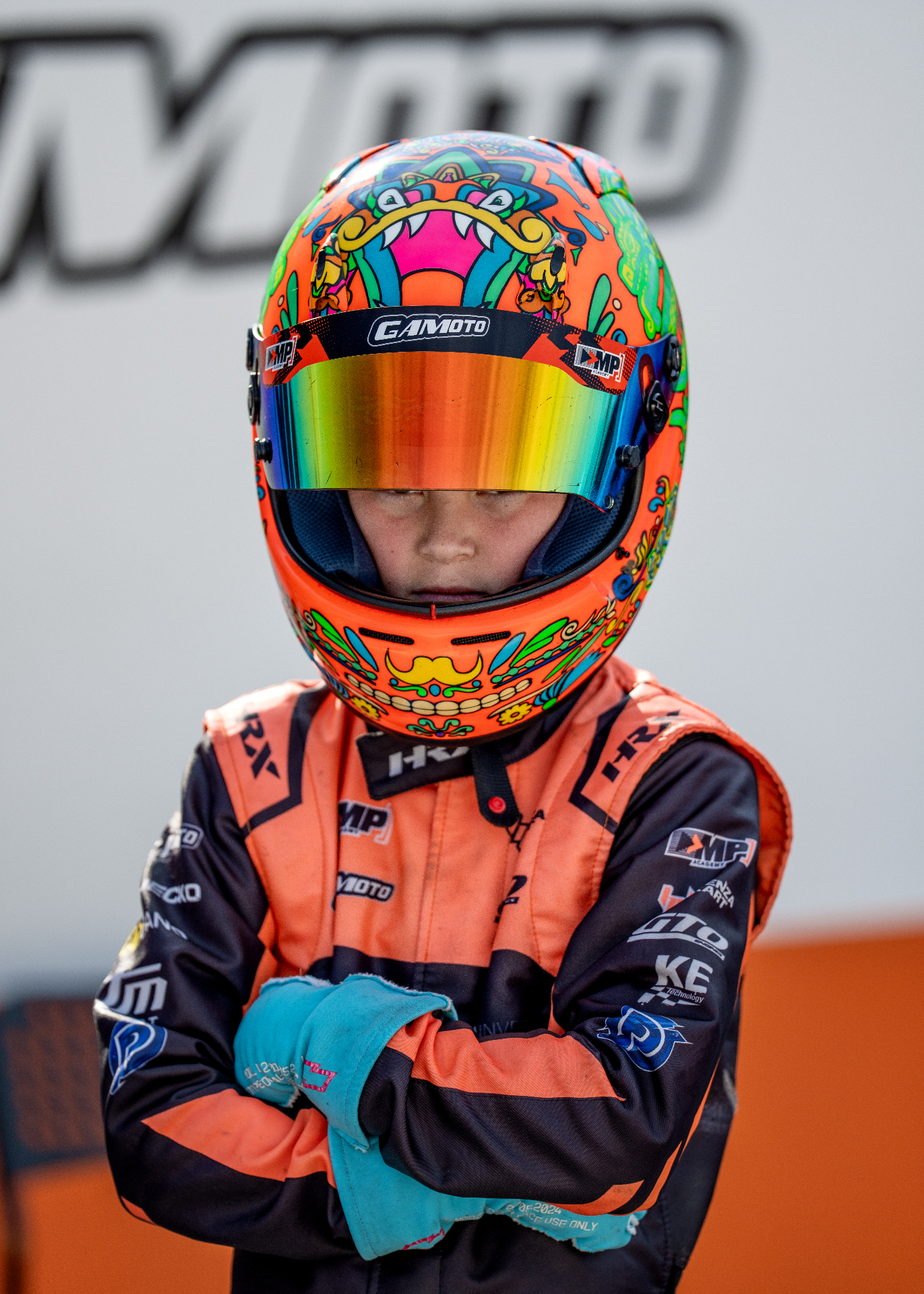 Front-facing helmet portrait of Guido with folded arms
