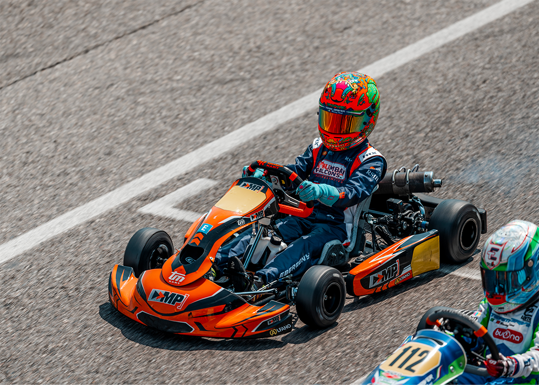 Guido racing in an orange kart during competition